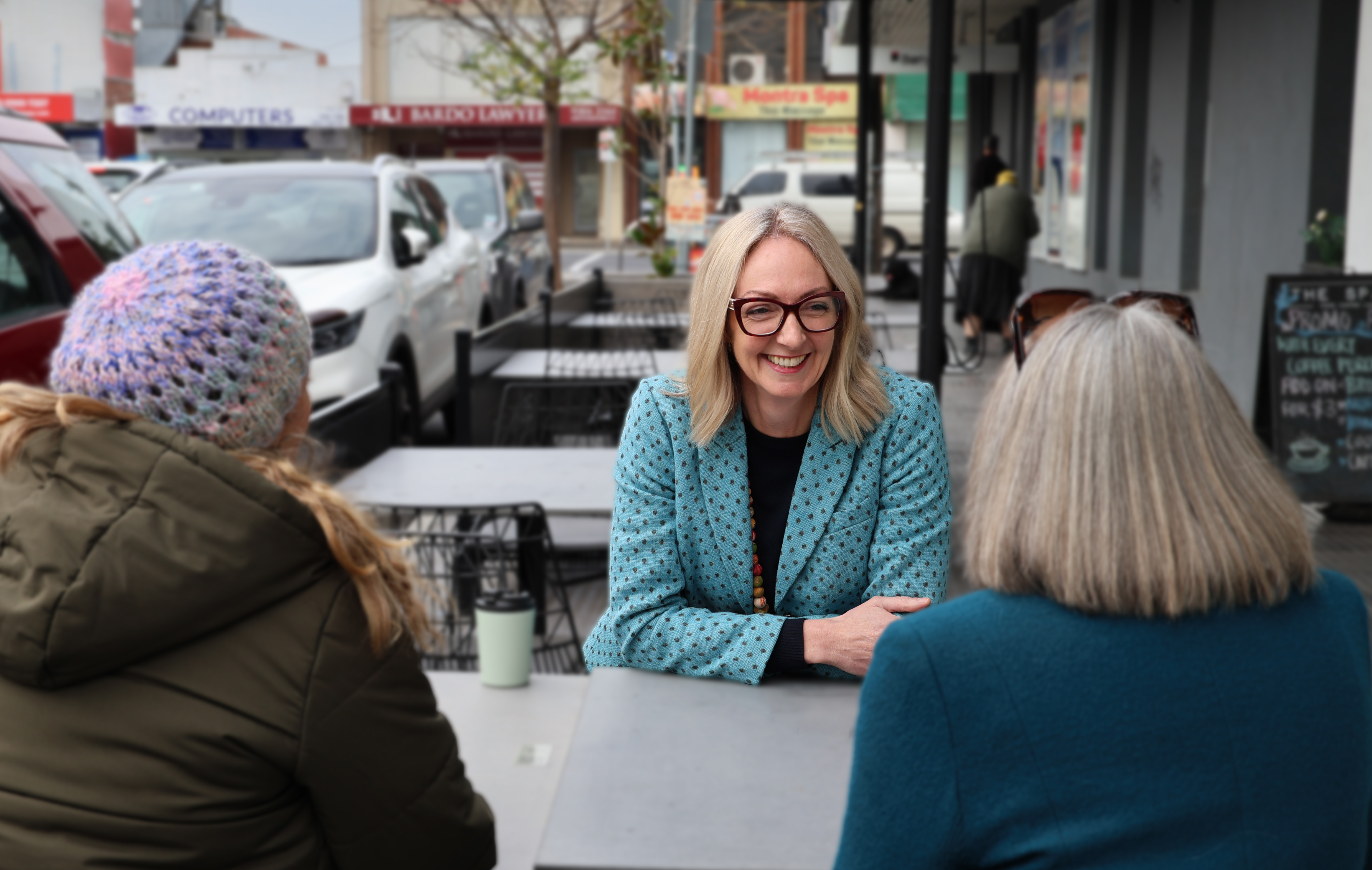 Senator Lisa Darmanin and two other women sit at a café table engaging in friendly conversation.